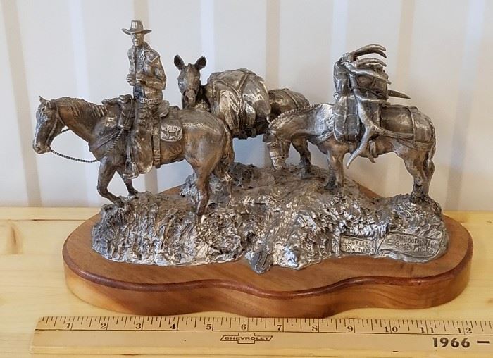 Limited edition pewter sculpture of a mounted cowboy with two pack horses, one of which is carrying elk antlers, #552/2500, entitled "The Outfitter", by Rusty Phelps (USA, 1963-), distributed by Fountain Creek Productions of Colorado Springs, CO, 7" x 11"