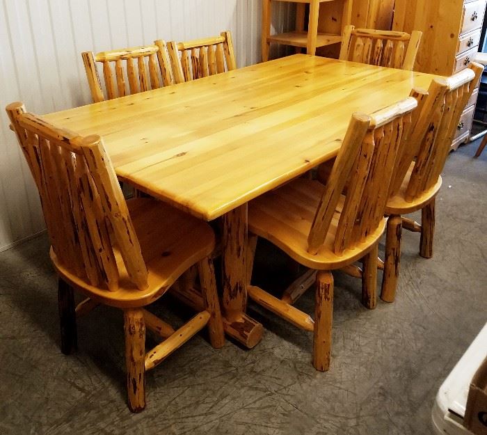Six foot Western lodge style stripped lodge pole pine log trestle base dining room table and six matching chairs, all by Montana Woodworks, from the Glacier Country Collection.