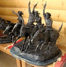 High quality late 20th century solid cast bronze sculpture of four mounted cowboys at a gallop firing their pistols into the air, from the 1902 original entitled "Comin' Thru The Rye" by Frederic Remington, on a green marble base, 24" x 27" x 27"
