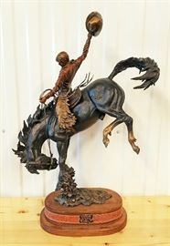 Painted bronze sculpture of a cowboy riding a bucking horse, #26/50,entitled "Wyoming Cowboy", by Christopher J. Navarro (Wyoming, 1956-), 30" x 18" x 9". This is a large size maquette of the monumental sculpture created by the artist for the H. Rochelle Gateway Center at the University of Wyoming.