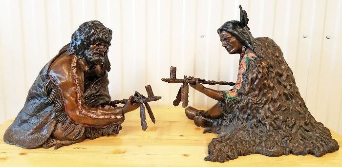 1993 two piece painted bronze sculpture of a seated Native American man and a seated mountain man sharing a peace pipe, #3/15, entitled "The Offering", by William Cie Conway (Texas, 20th century). The Native American measures 18" x 18" x 16", and the mountain man is 14" x 20" x 14".