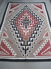 Circa 1960s/70s hand woven Navajo rug, probably from the Four Corners area of New Mexico or Arizona, measuring 5' x 7 1/2' . Please view closeup photos on auction site carefully for condition.