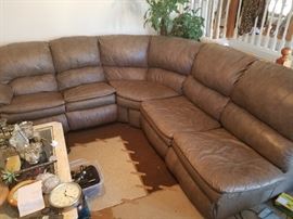 Large genuine leather sectional includes chaise lounge, (not pictured). Has recliner at one end and sofa sleeper inside.