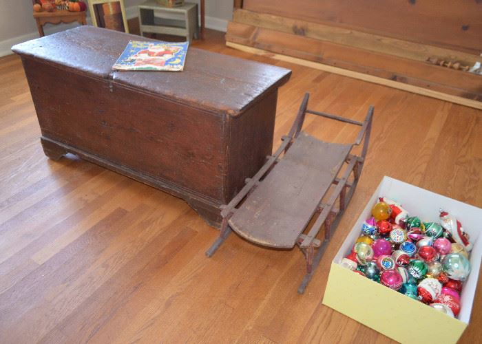red painted blanket chest; sled; ornaments