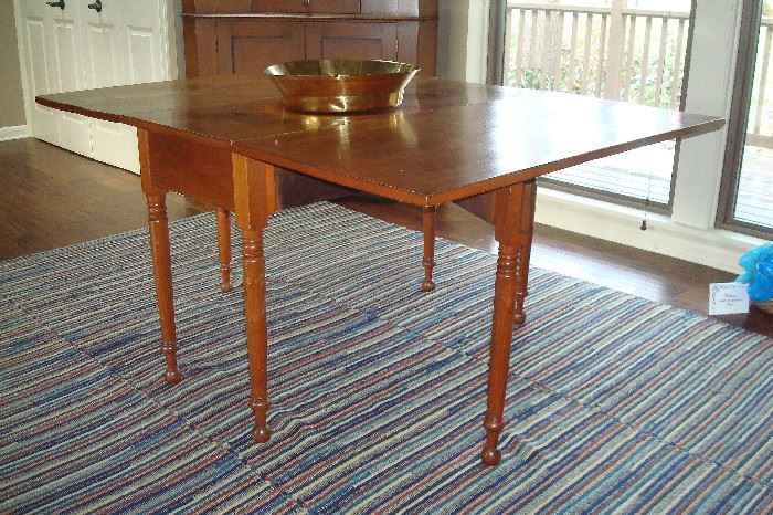 1840's antique walnut gate leg table and one of two hand made  btaided rugs.