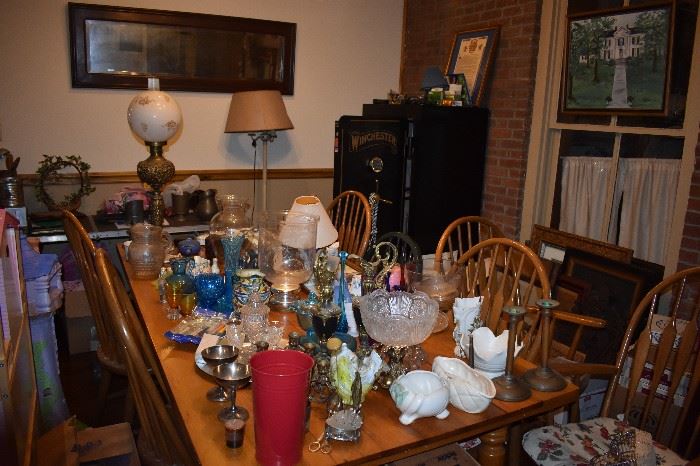 General Picture of Antique Dining Table filled with Wonderful Antique & Collectible Items plus Lamps and Lanterns, Art Work, and Winchester Gun Safe