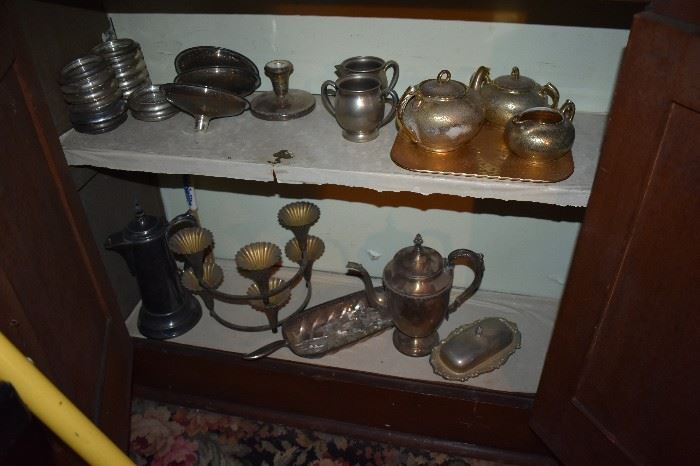 Corner of Top left shelf has 16 matching Sterling and Glass Coasters plus 2 of another design in Sterling and Glass, Pewter Pitcher and Creamer, Copper Lustre Style Tea Set with Tray while bottom shelf has Antique and Vintage Silver Coffee Pot, Nut Server with Handle, Silver Crook Necked Teapot, Covered Butter Dish and Candle Holders