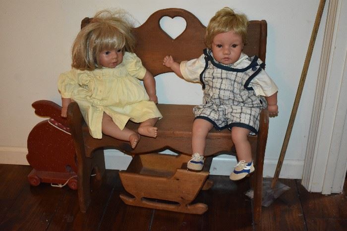 These 2 Dolls Welcome You to the Toy & Games Room while sitting on a Carved Wooden Heart Bench notice the Wooden Sled Cradle also!