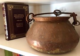Vintage copper pots, collection of leather-bound classic book titles.