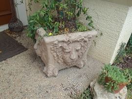 Pair of planters with lion faces on all four sides.