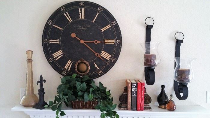 Large round clock, and accessories over fireplace in den