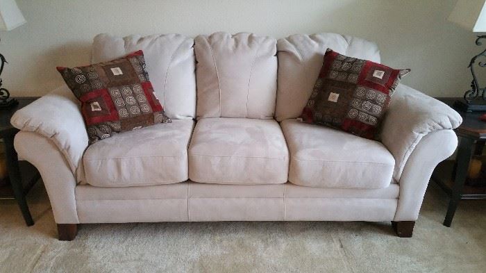 Very nice off white three cushion sofa in living room