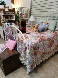 The most charming cast iron bed... Looks great with the expansive wicker bedroom set we also have in this estate sale. Antique trunk at the foot of the bed.