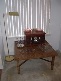 One of three matching tables with some depression glass and a replica radio.