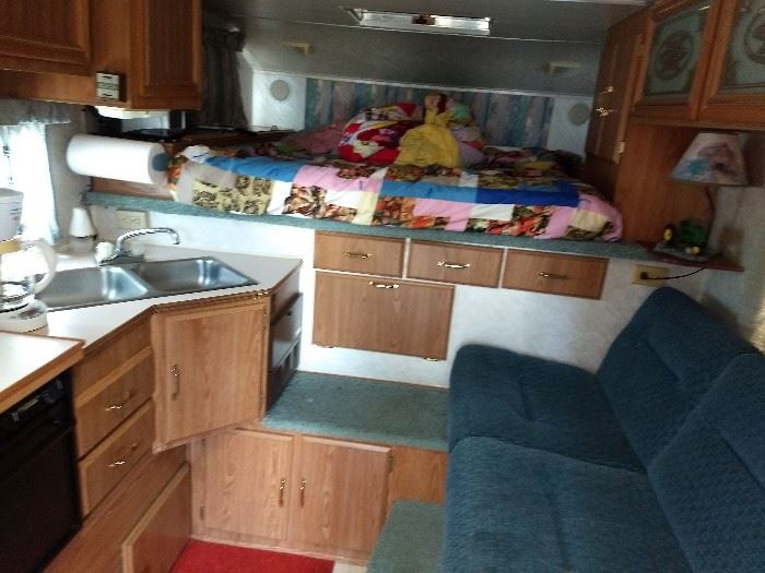 Inside camper (bed/seating/sink/cabinets)