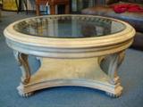 LARGE ROUND WOOD COFFEE TABLE WITH BEVELED SMOKE GLASS INSET TOP - Antique White color with scroll columns.