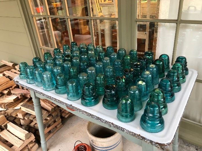 Variety of glass insulators from clear to dark aqua blue.  These are great for drilling through the tops and making pendant lights.
