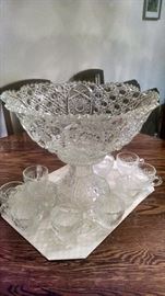 Vintage punch bowl on stand with cups.