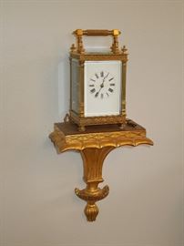 Elegant antique French gilded brass striking carriage clock in elaborate fretwork case with beveled glass.  All original and fine running order.  Circa 1900. 
 Displayed on a gilded Italian terracotta wall bracket.