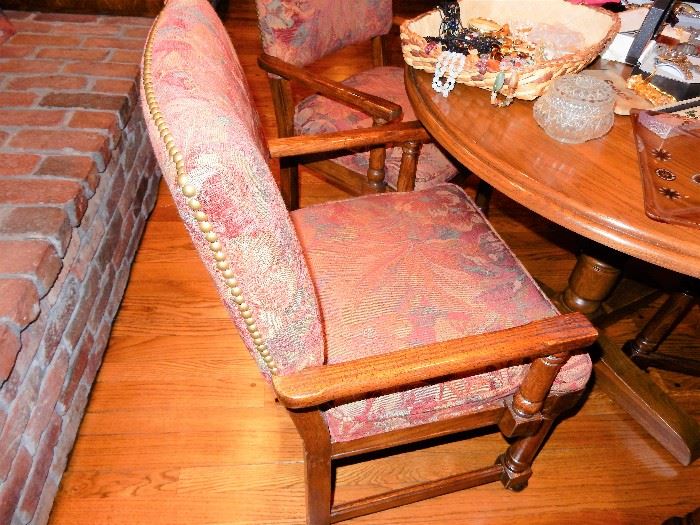 Oak game table with 4 upholstered chairs, chairs are on casters and have nail head trim,