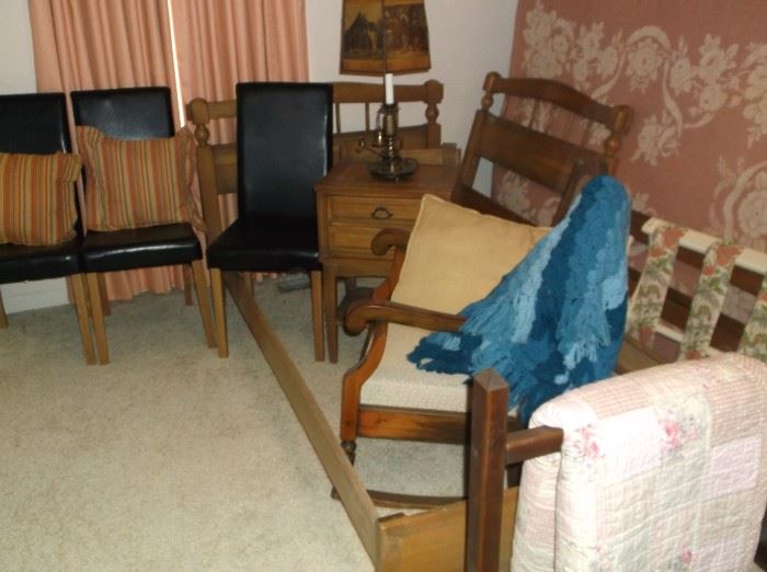 Twin beds, side table, and three of four black faux leather chairs