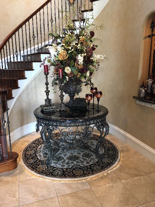 Gorgeous wrought iron and marble table with large floral arrangement and decor and round rug