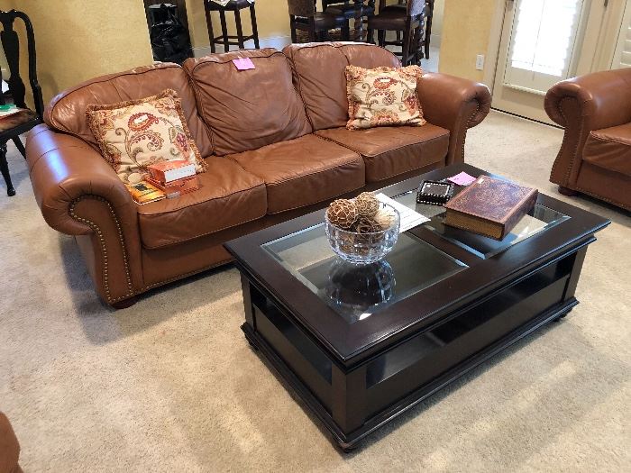 Leather sofa with nailhead trim and lovely black coffee table  with glass inserts and 2 drawers with shelf 