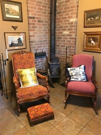 A pair of antique rocker is sitting in front of the wood-burning stove in the front hall