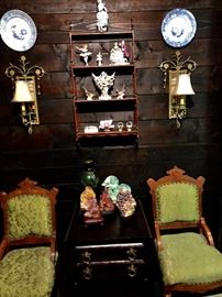  A section of the Victorian living room, the shelf holds English, French, German and American bisque the table holds a dark jade urn, a light green Buddha and several Chinese stone carvings 