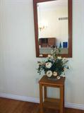 Stickley mirror, artificial plant, small table.