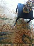 Oriental rug with black table and artificial flowers