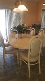 Metal, Contemporary Dining Table with 6 Chairs.  Cream Color. Chairs have Ostrich Like designed Seat & Backs. Table is shown with the Leaf in place
