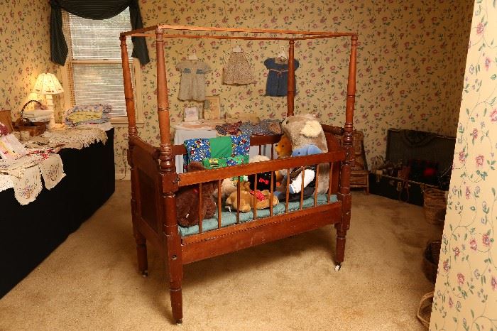 Antique baby crib filled with stuffed animals.