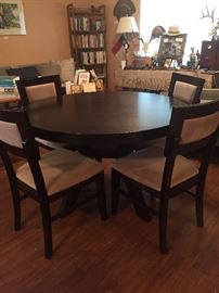 Black dining table with 4 ultra suede upholstered chairs. 