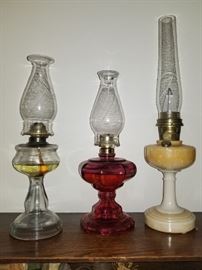 Several antique oil lamps, including a peach luster alladin Nu Type Model B (on right)