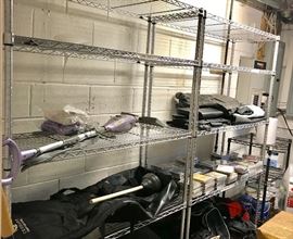 Two of approximately one dozen shelving units for sale, some chrome as shown and some white.