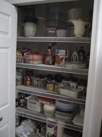 Cupboard full of storage containers and sealed cooking items. 