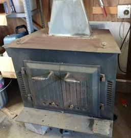 Black Bart Heating Systems dual use cast iron stove, with working blower unit. Model 3200S.  Still installed within garage, so aluminum stack will need cutting. 