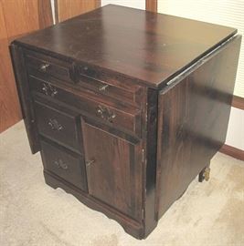 Folding sides on this sewing cabinet/work table.