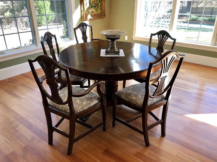 Impeccable round English dining table with 8 Shield Back chairs upholstered in gray and white pattern