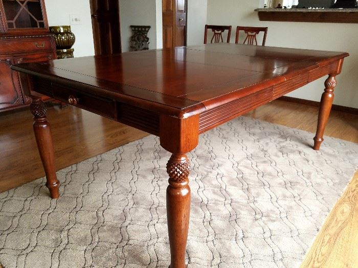 Wood dining table by American Signature, with one 18" leaf and a drawer at each of the table.  54" long when closed, 72" with leaf and 41.5" wide.