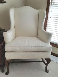 Large wing-back chair, cream color damask fabric, solid wood frame, cabriole legs.