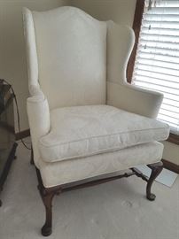 Large wing-back chair, cream color damask fabric, solid wood frame, cabriole legs.