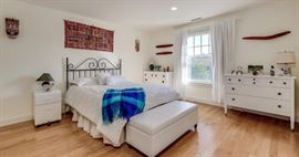 Queen bed, storage at foot of bed, vintage bureaus.