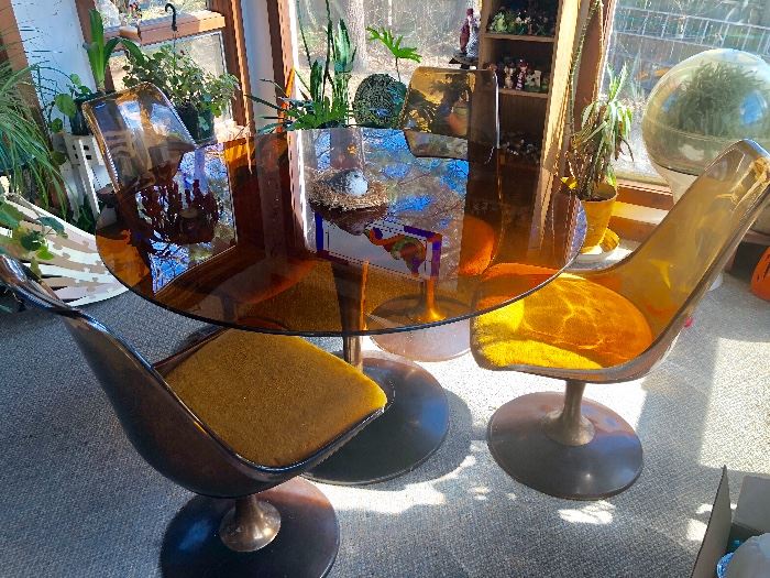 Chromcast Mid-century and in nice condition. Amber smoked glass top and smoked lucite chairs with heavy tulip base.