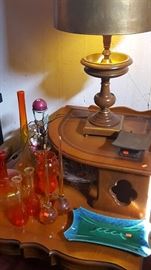 Amberina glassware assortment and ashtray. Vintage wood lamps. Leather and wood vintage end table.