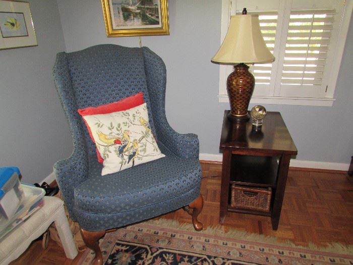 Blue, newly upholstered spoon foot wing chair, Mahogany side table with lower basket, decor lamp, pillow decor