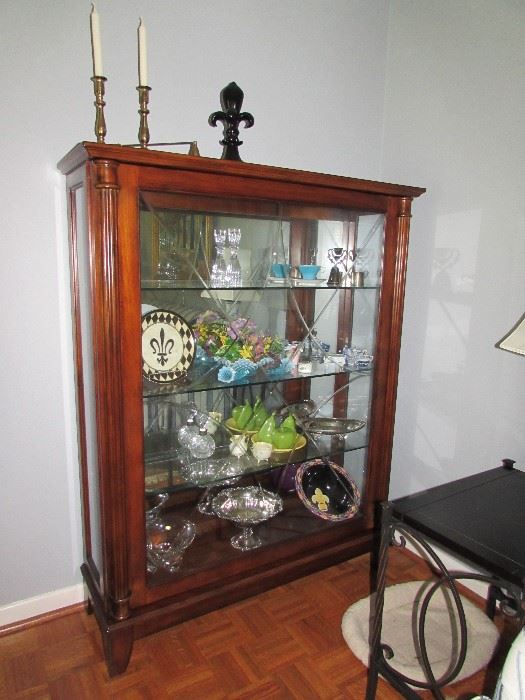 Henredon sliding front Mahogany display cabinet wiht glass shelves.  Brass candle sticks by Virginia Metal Crafters and others.  Silver and silverplate items.