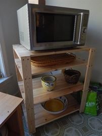 Microwave and wooden shelving.