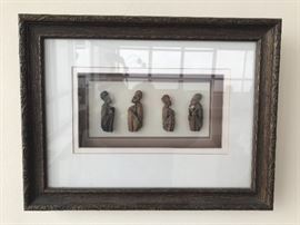 Two pairs of 3 inch African carved seated figures in conversation in framed shadow box.